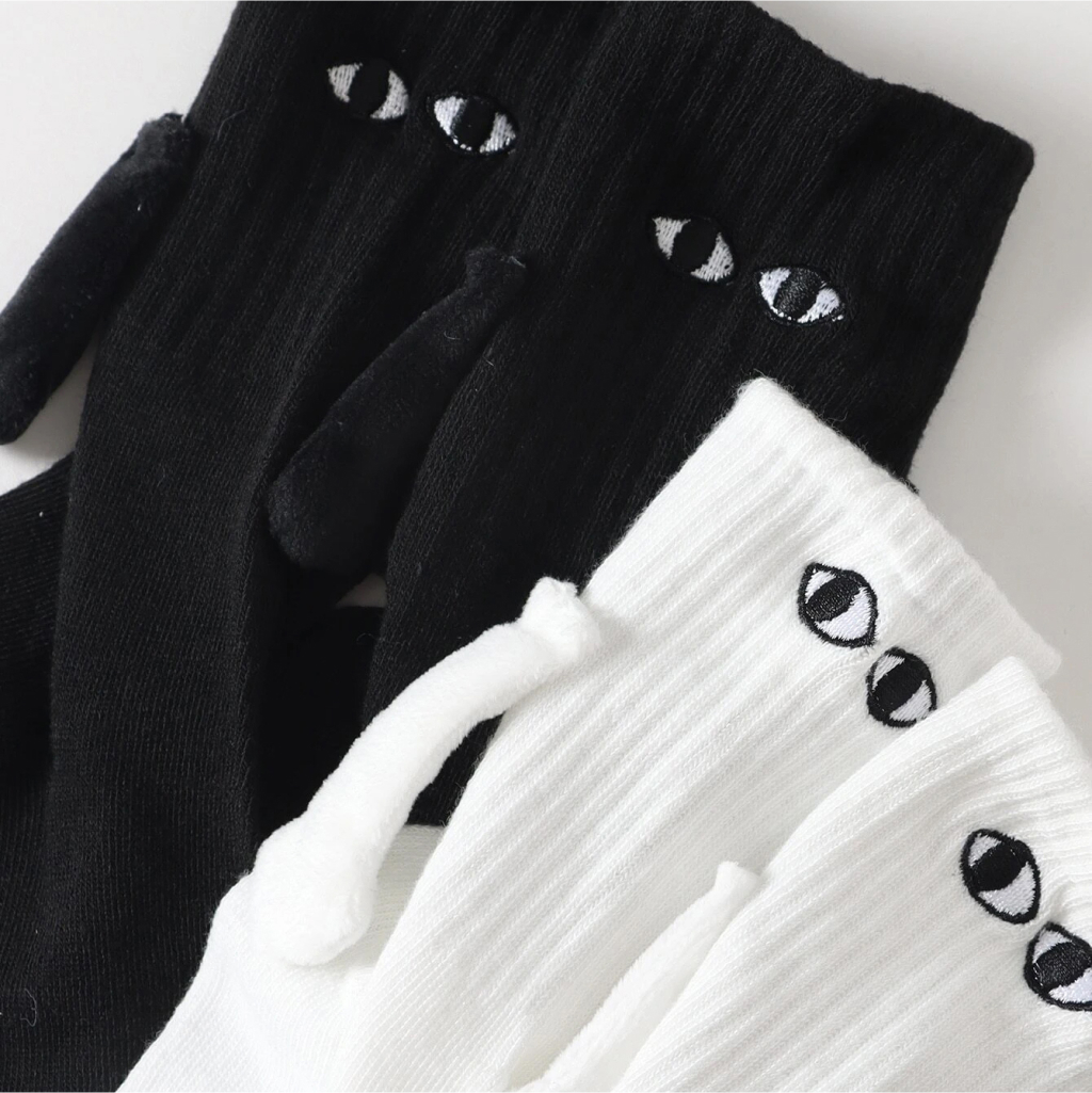 White And black socks with eyes, arms and magnetic hands